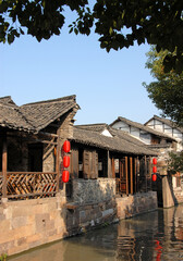 Wuzhen Water Town, Zhejiang Province, China. A traditional wooden building with red lanterns beside a canal in the old Chinese town of Wuzhen. Wuzhen Canal Town is also known as the Venice of the East