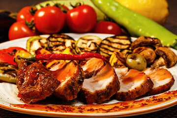 Closeup of grilled tasty meat served with sauce and pepper. Lots of ingredients behind the meat food