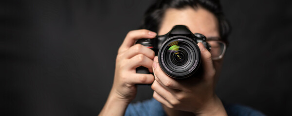 photographer take pictures Snapshot with camera. man hand holding with camera looking through lens.Concept for photographing articles Professionally.. - obrazy, fototapety, plakaty
