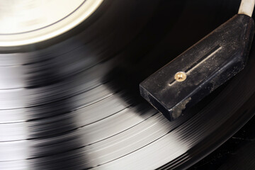 Black vinyl record spinning on the turntable. Analog audio playback