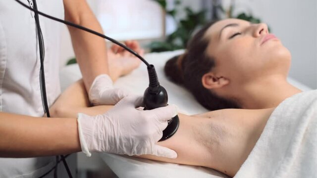 Video of cosmetologist makes the procedure an ultrasonic cleaning of skin of a beautiful young woman on the spa center.