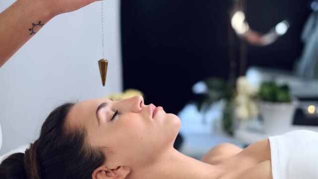 Video of beautiful young woman having reiki healing treatment in health spa center