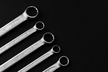 Steel closed end ring wrenches on black background with copy space