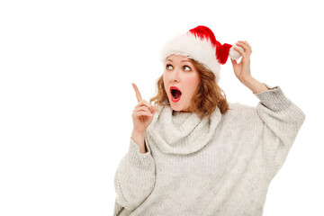 Young happy woman with curly hair in winter hat standing over white background smiling with happy face looking and pointing to the side with thumb up. Place for your text