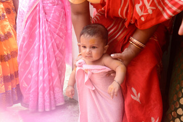 Cute happy baby in pink bath towel close up.