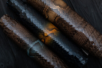 Colorful rolls of python leather. Brown dark palette.	
