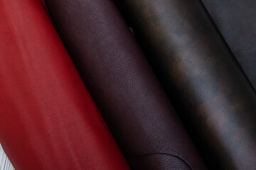 Colorful rolls of cow leather. Red brown palette.