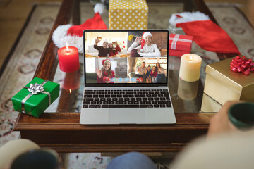 Happy caucasian friends and family at christmas smiling on laptop group video call screen