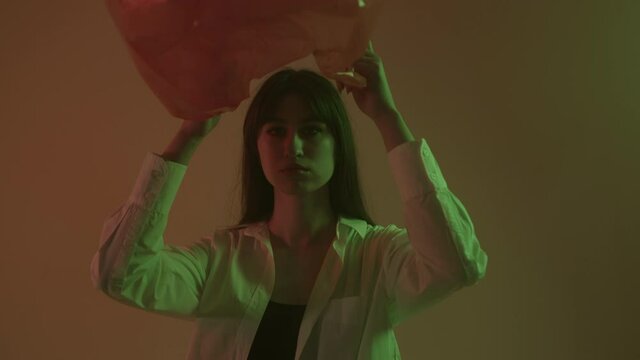 The girl puts a plastic bag on her head, showing that it can be used many times.