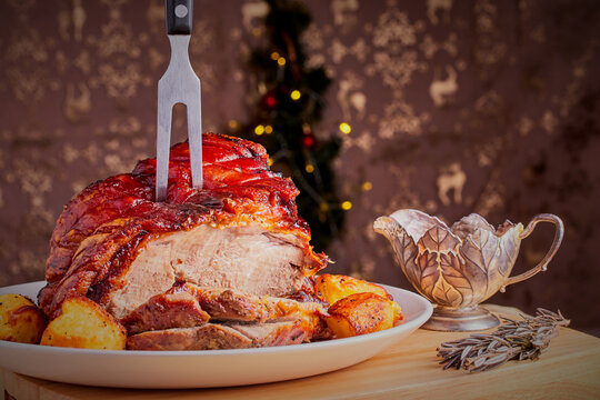 Christmas pork shoulder joint,with roast potatoes,that has just been sliced.