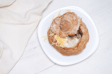 Creamy soup with mushrooms and cheese in bread.