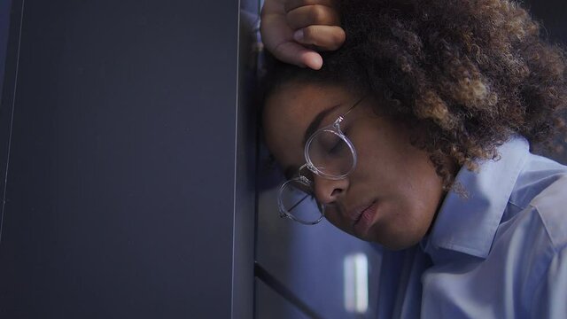 Depressed african american woman leaning head on wall, trying to cope with hurt