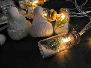 Beautiful Christmas background, garlands on a black background, little Christmas trees illuminate the lights, Christmas holidays concept, merry Christmas, little hats, skates on a black background