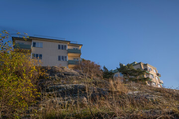 Functionalist style of apartment houses and view point at a wood promenade with benches and trees at the cliff water front in the district Marieberg a sunny color full autumn day in Stockholm