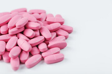 Obraz na płótnie Canvas Pink pills with multivitamins on a white background.
