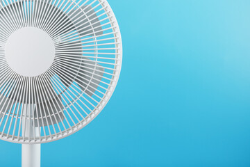 Electric fan in white with a modern design for cooling the room on a blue background