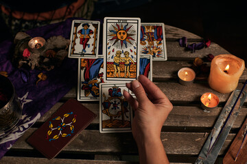 Close-up of a fortune teller reading tarot cards - obrazy, fototapety, plakaty