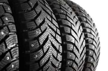 New winter tires with studs close-up. Tire tread. Set of winter car tires