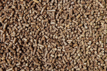 Hygienic cat litter. Biodegradable wood granules, pellets. Brown background, top view