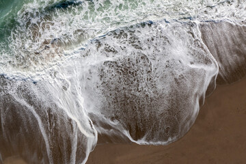 olas que rompen con fuerza en la orilla de la playa - obrazy, fototapety, plakaty