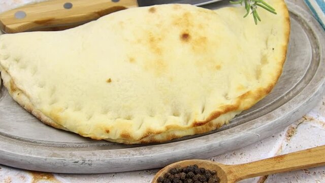 pizza calzone sur une planche &agrave; d&eacute;couper