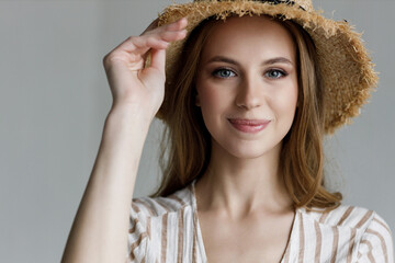 Portrait of a young happy woman in hat in studio