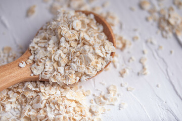 oatmeal in wooden spoon and fresh milk on white background healthy food