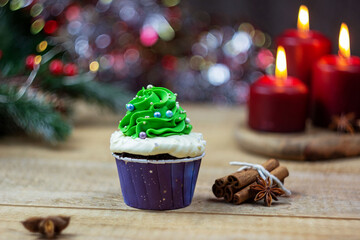 Christmas cupcakes. Candles and an elegant spruce. Selective focus, place for text.