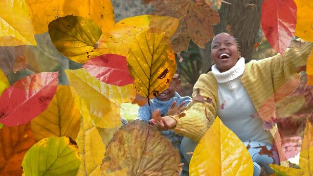 Animation of autumn leaves over african american family throwing leaves in park
