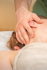 Obraz na płótnie Canvas Osteopath doing massage on the female head in rehabilitation clinic center