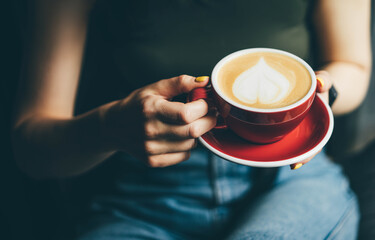 Woman hands holding a cup of coffee in her hands.