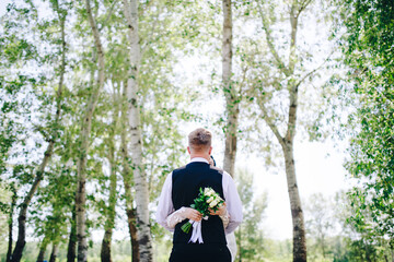 the bride hugs the groom and holds a beautiful bouquet in her hands