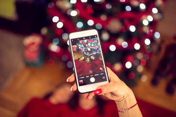 Three girls friends celebrating Christmas at home-picture with mobile phone