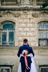 the bride hugs the groom and holds a beautiful bouquet in her hands