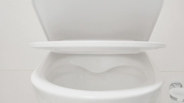 white toilet lid lowers smoothly closes 4K
