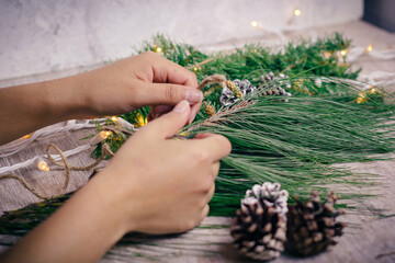woman's hands putting together a christmas wreath