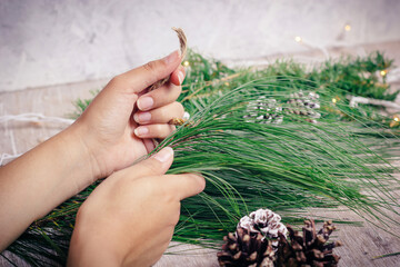 woman's hands putting together a christmas wreath