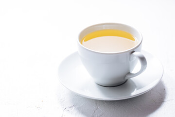 Cup of tea in white cup with chocolate chip cookies as a part of a scene, on a white background