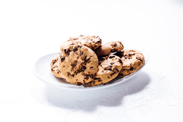 Cup of tea in white cup with chocolate chip cookies as a part of a scene, on a white background