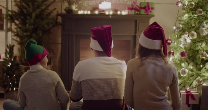 Happy family near fireplace on Christmas eve