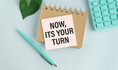 Now it's your turn text, inscription, phrase written in a notebook that lies on a dark table with a...