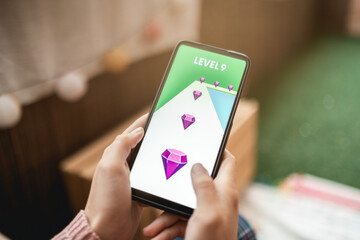 Young girl playing online video games on mobile phone app - Focus on screen