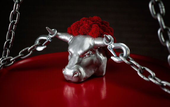 figurine of a bull's head with transportation hooks on horns and a metal chain