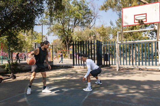Defendiendo en pr&aacute;ctica de baloncesto entre dos jugadores latinos en cancha de la Ciudad de M&eacute;xico