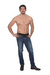 Fototapeta premium man shirtless and with blue jeans looking at camera on white background