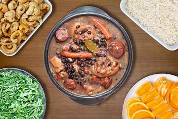 Traditional Brazilian feijoada, with typical side dishes, pork rinds, cabbage, orange and rice . Top view
