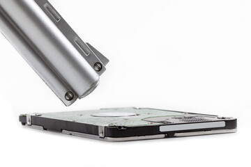 2.5 inch HDD hard drive and a gun barrel pointing towards it. Private digital data safety, ransomware attacks, hacker threats, information security, file deletion simple abstract concept, nobody
