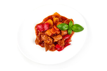 Stewed meat with vegetables, homemade goulash, isolated on white background.