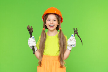 A little girl in a construction safety helmet and a wrench. Renovation of premises. Construction work on redevelopment. isolated background.