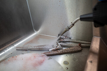 some bloody cutters are cleaned with a high pressure cleaner after an operation